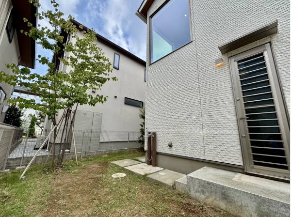 外観とマッチする外部シャワー付きのお庭